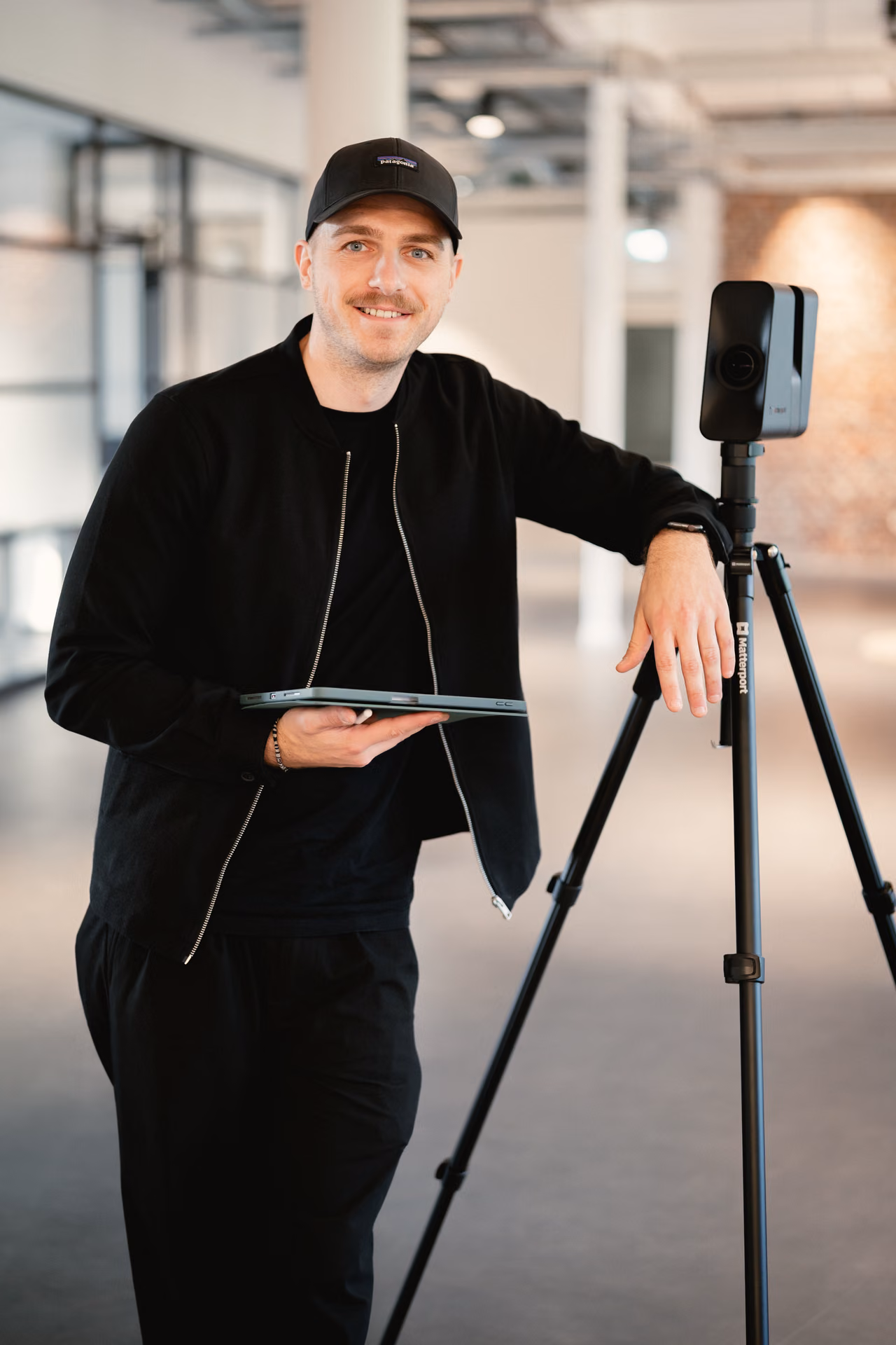 René Röbke lehnt an seiner 3D-Kamera auf dem Stativ, das iPad in der Hand